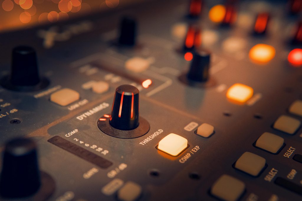 A detailed view of an audio mixer with glowing knobs, perfect for music production themes.